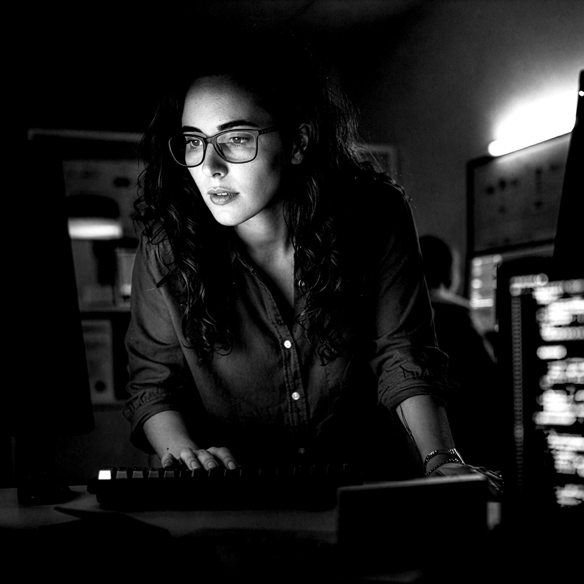 Professional die op een laptop werkt in een gefocuste omgeving, wat cybersecurity- en datagedreven applicatiediensten illustreert die veilige digitale transformatie en bedrijfsresultaten ondersteunen in sectoren zoals financiële dienstverlening, productie en telecommunicatie.
