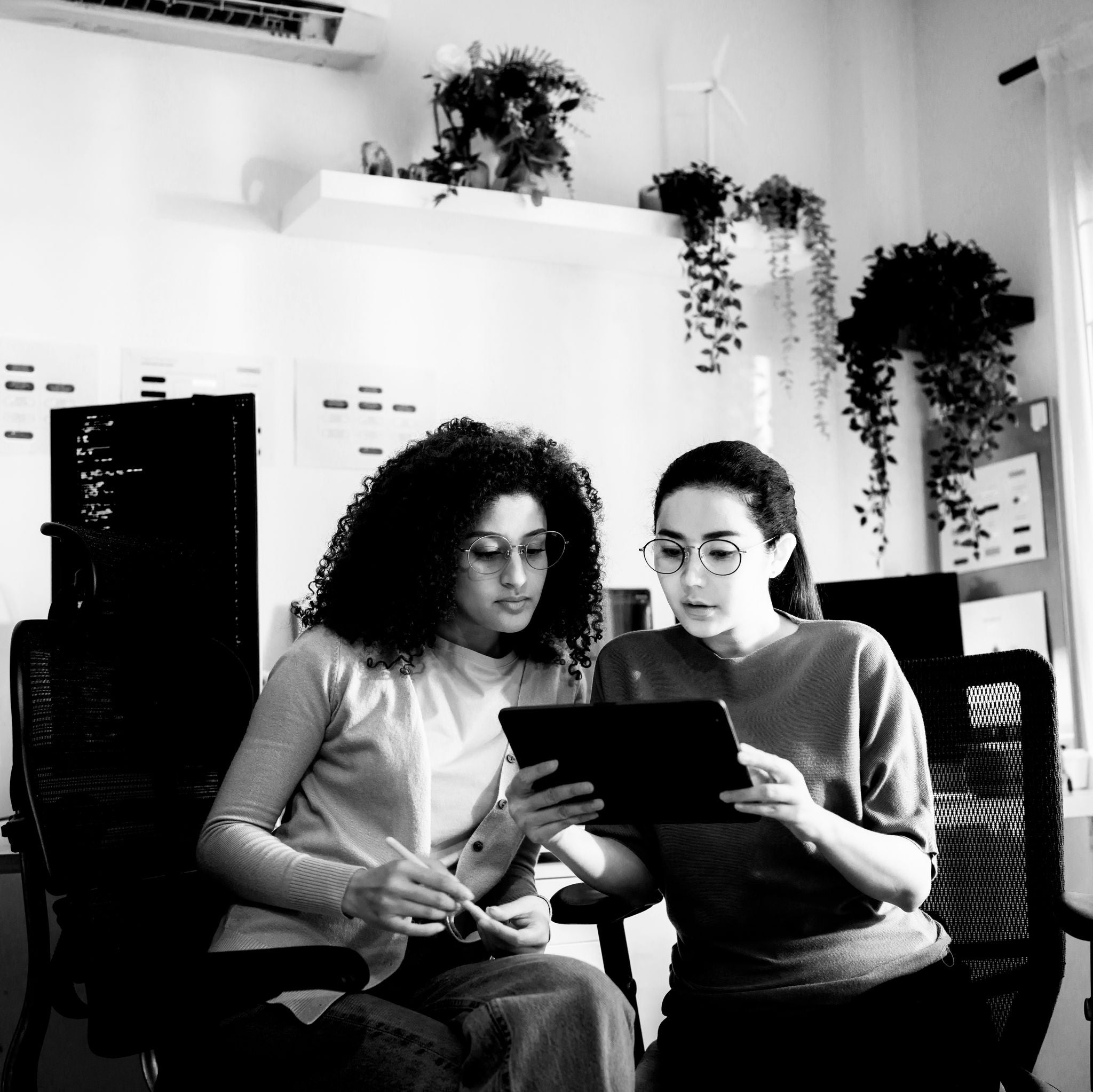 Twee professionals analyseren informatie op een tablet in een moderne werkomgeving, met nadruk op AI-adoptie, digitale transformatie, samenwerking, innovatie en het vertalen van technologische beloftes naar concrete bedrijfsimpact.